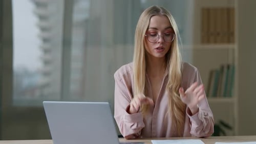 Woman Talks Online Via Laptop in Home Office