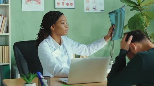Beautiful Woman Doctor Consults Her Patient in the Hospital Using Chest Xray Scan Explaining Side