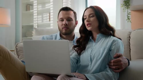 Happy Young Couple Using Laptop for Ecommerce Doing Online Shopping with Shop App Together at Home