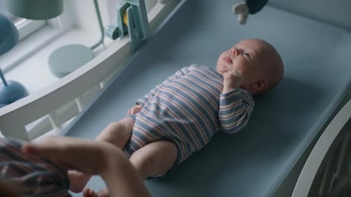 Parent Changing Adorable Baby at Home