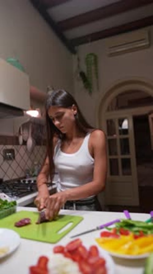 Young Woman Prepares Vegetables in Kitchen