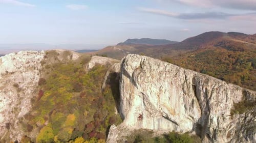 Luftschwenkaufnahme großer hoher Felsen am Rand eines Berges