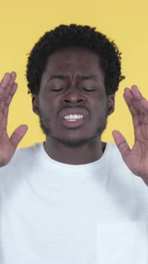 Upset Young Man Yelling Against Yellow Background