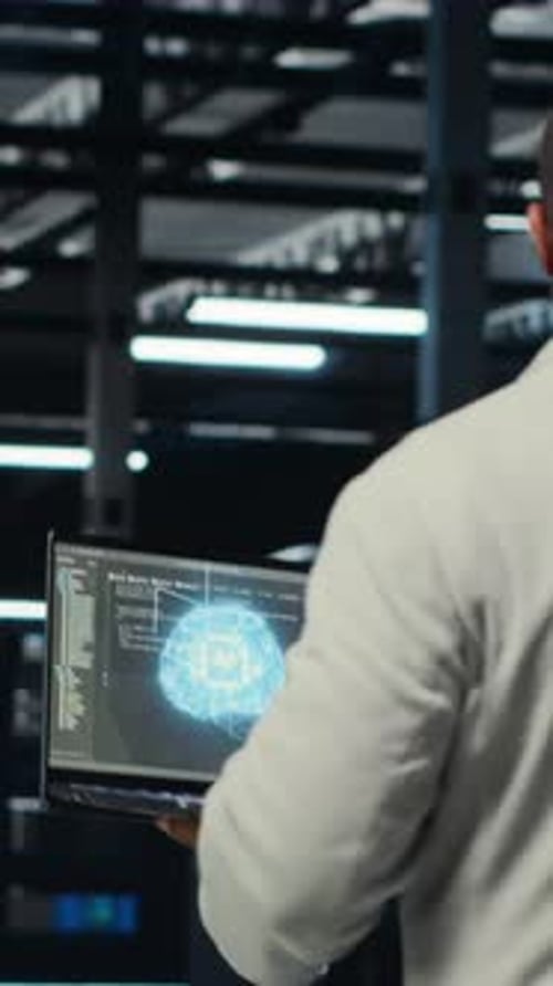 Técnico de vídeo vertical usando laptop no data center gerenciando a virtualização de servidores