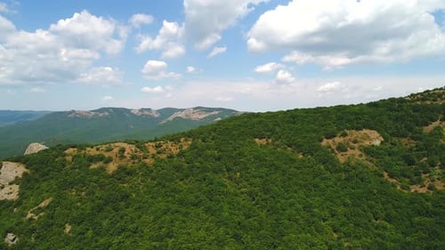Lush Green Mountain Range Under a Cloudy Sky