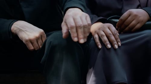 Close-Up of Man Holding Hand of Wife while Supporting Her in Cemetery