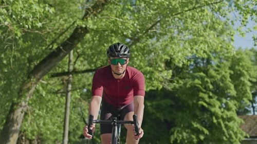 Gut gebauter Athlet, der Rennrad im Freien in der Wildnis fährt