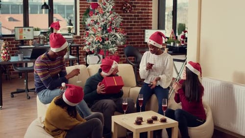 Diversos colegas de trabalho trocando presentes surpresa na festa de Natal