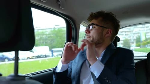 Young Man in Suit Rides in Car
