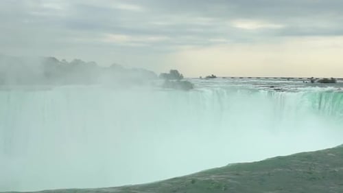 Slow motion panning wide shot of the flowing niagara falls on the niagara river near the canadian pr