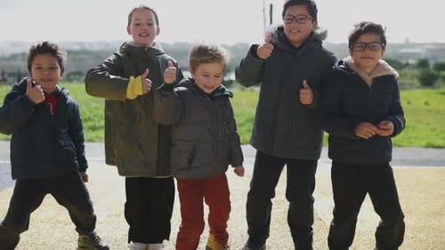 Group of Children Give Thumbs Up Outside