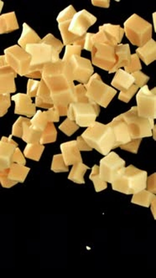 Maasdam Cheese Flies Up and Falls Down on a Black Background Filmed on a Highspeed Camera at 1000