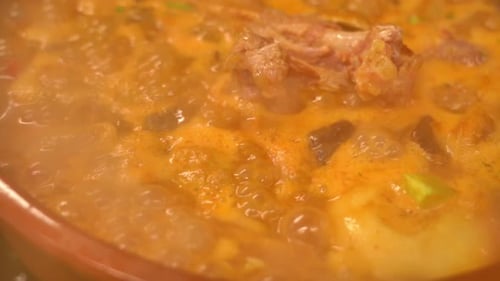 A bowl of soup with meat and vegetables