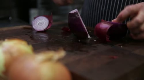 Chef preparing food by cutting red onions