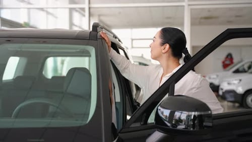 Woman Inspecting a Car Before Purchase at Dealership Showroom