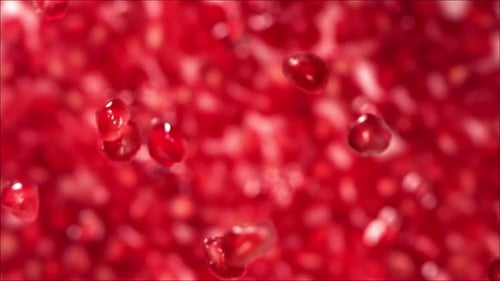 Pomegranate Seeds Falling on Water Surface with Pomegranate Seeds