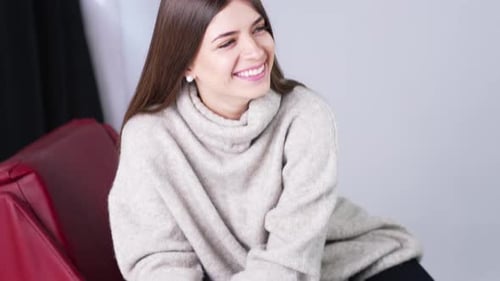 Woman in Sweater Posing in Stylish Red Chair