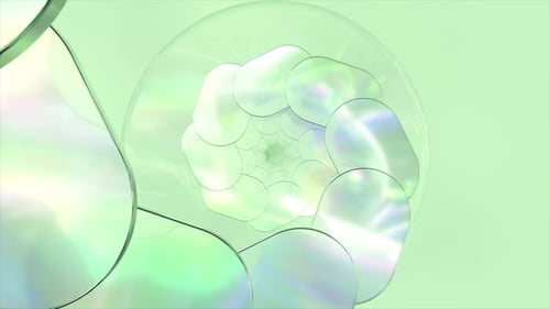 L'animation abstraite montre une spirale qui se déplie composée de formes ovales irisées sur un vert clair
