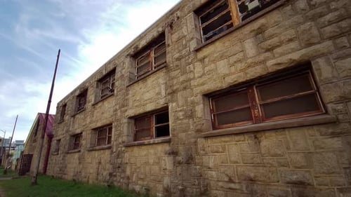 Moving shot of deteriorating prison cellblock exterior at Eastern State Penitentiary.
