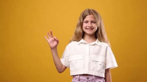 Smiling Girl Making an Okay Hand Gesture