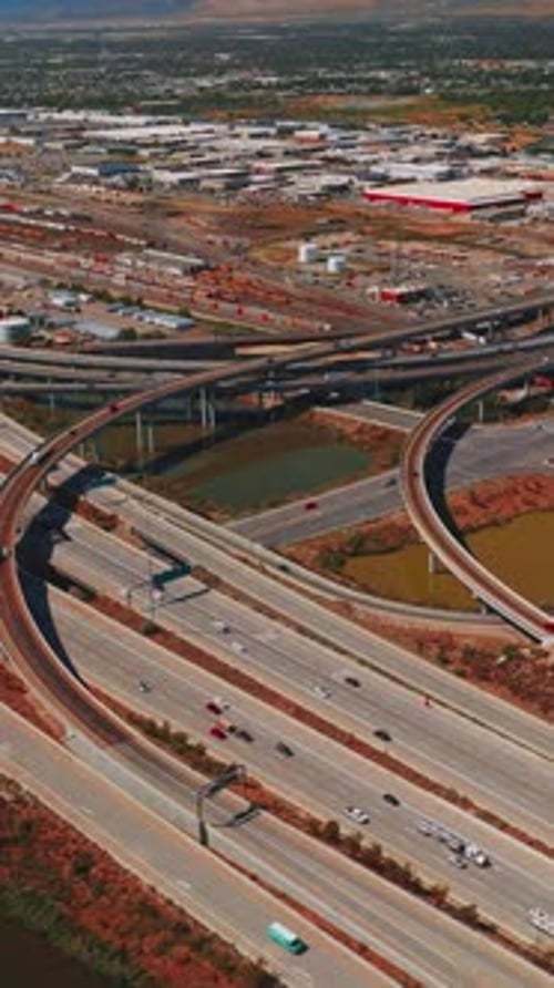 Highways and skyways with multiple cars moving by. Vast panorama of Salt Lake City