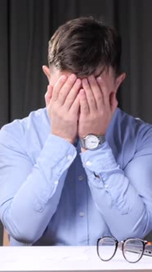 Vertical Video Stressed Office Worker Covering Face with Hands at Desk