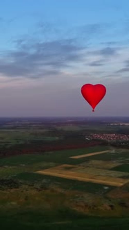 Red air balloon in love heart shape. Panoramic view on nature landscape