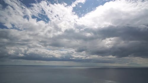 Timelapse Fluffy Cumulus Clouds Moving in Bright Sunset Sky Over Calm Sea Abstract Aerial Nature