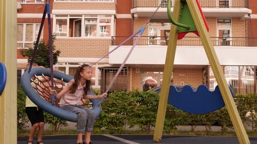 Children Play on Tire Swing at Playground