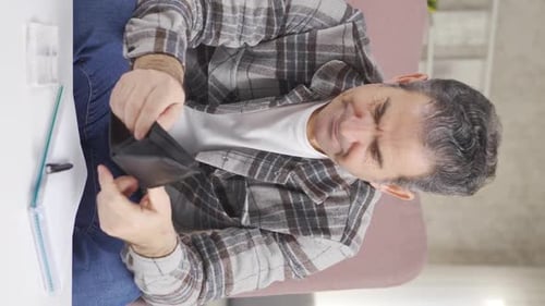 Stressed Man Counting Money at Home