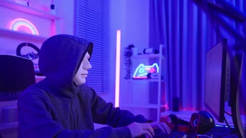 Short of computer hacker wearing white mask stealing data from a laptop.