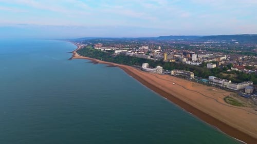 Aerial panning view, Folkestone sandy beach front scenery, hotel line