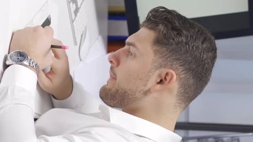 Vertical Video of Male Architect are working on a model of a building or shop in the office.