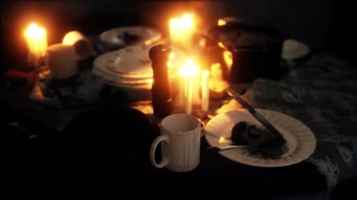 Flickering Candles on Dark Dinner Table for Cozy Atmosphere