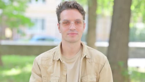 Young Adult Gives Thumbs Up Gesture Outdoors