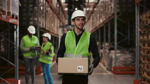 Guy Worker Carries Cardboard Box in Warehouse with Goods