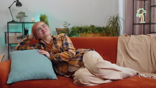 Joyful Woman Relaxing on a Sofa Indoors