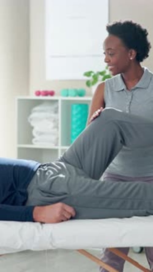 Physical Therapist Assisting Man with Leg Exercises