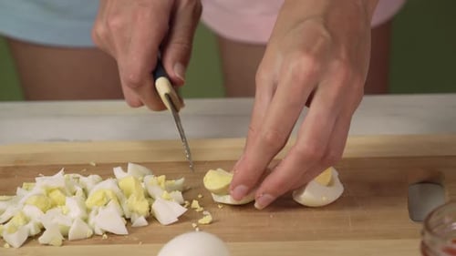 Woman Chopping Hard Boiled Eggs on Board
