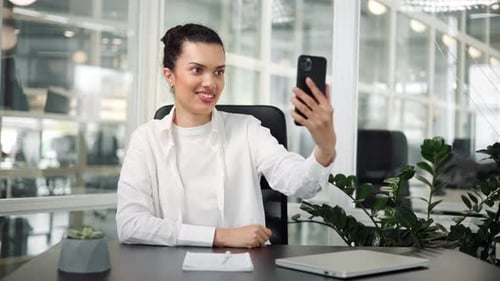 Business Woman Having Video Call on Smartphone in Modern Office