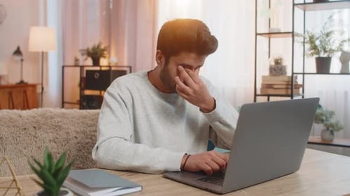 Man Working on Laptop in Bright Home Office