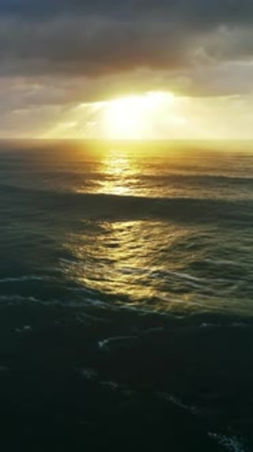Vue aérienne sur de grosses vagues et un coucher de soleil Théâtral