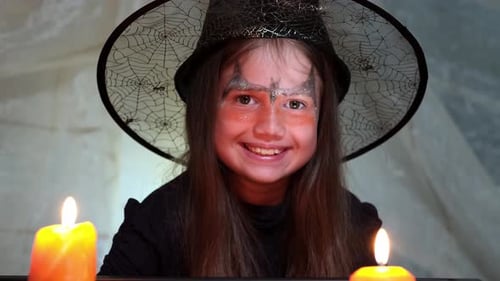 Child in Witch Costume Smiling at Camera