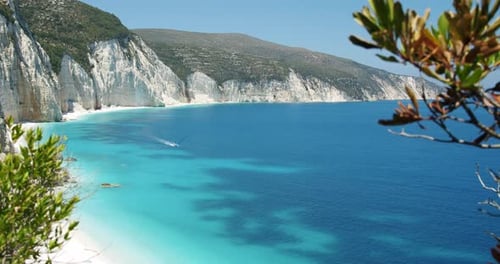 Beautiful Fteri beach on Kefalonia Island, Greece. White rocks and blue lagoon surrounded by green f