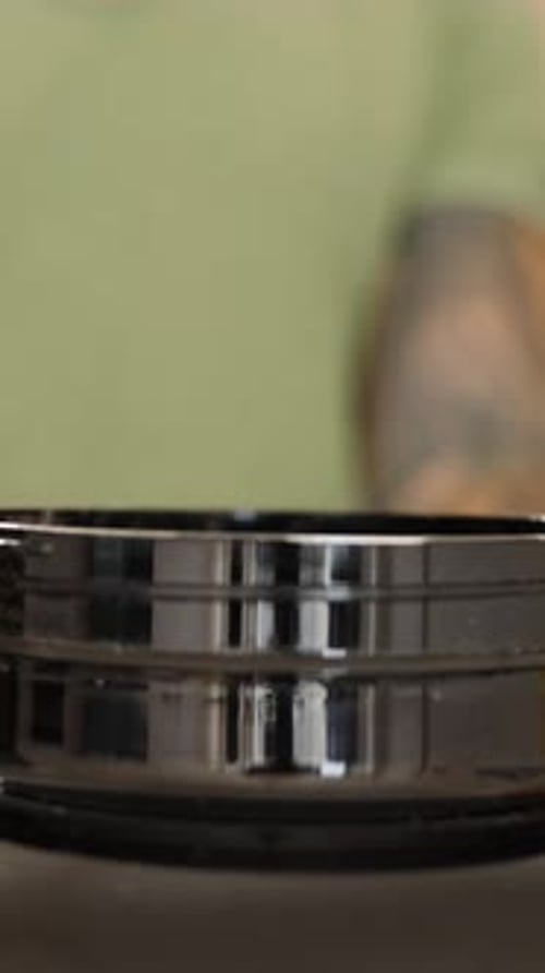 Vertical video. Close-Up of a Black Jar with Protein Powder on a Measuring Spoon Being Scooped.