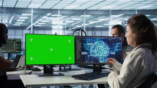 Employee Works on Green Screen Computer in Server Hub Using AI to Process Data