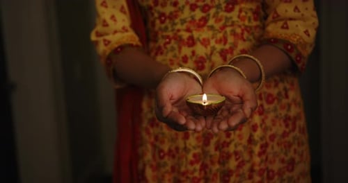 Glowing Diya Lamp Held in Hands During Diwali