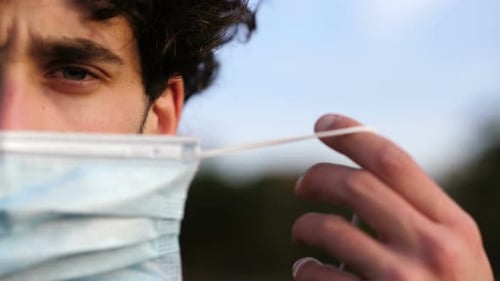covid19 - thoughtful man wears the mask looking serious at camera