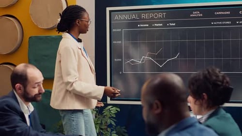 Woman Presenting Data to Colleagues in Modern Office