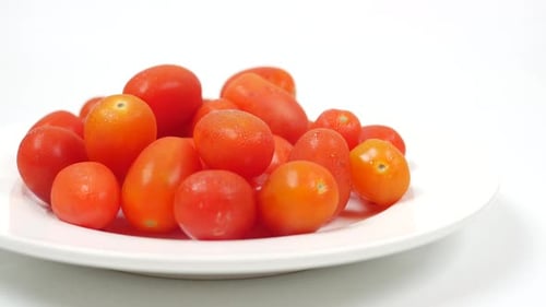 Rote Kirschtomate auf einem Teller auf weißem Hintergrund